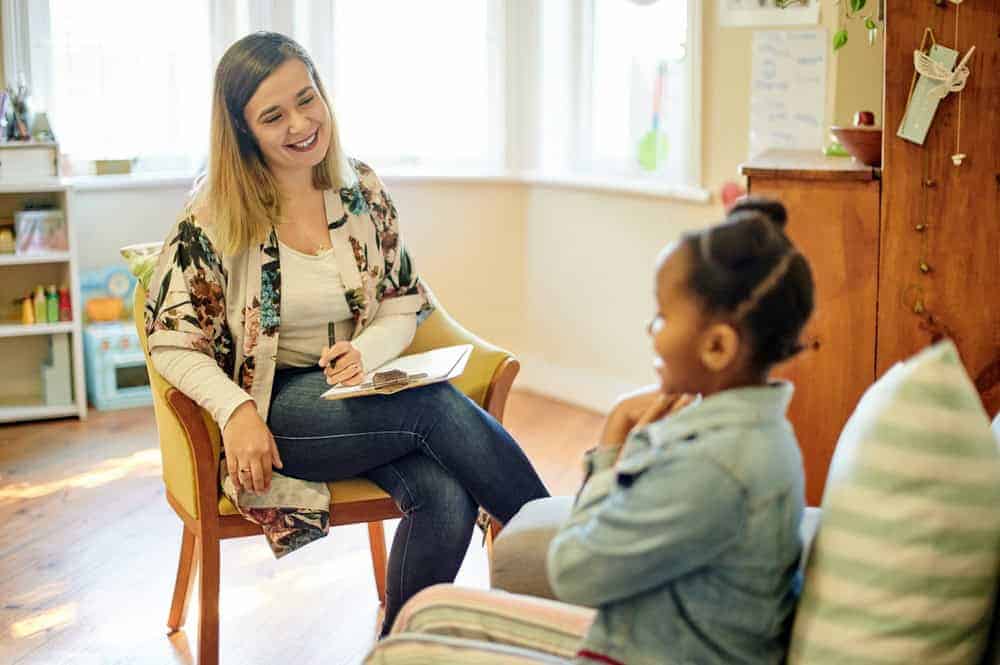 Psychologist, black kid and consultation in office for support, help or mental health. Psychology, therapist and girl consulting happy woman for counselling, therapy or talking for advice in clinic.