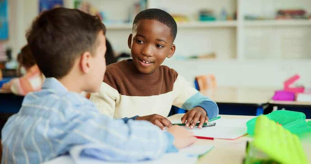 two young children smiling and talking to each other 